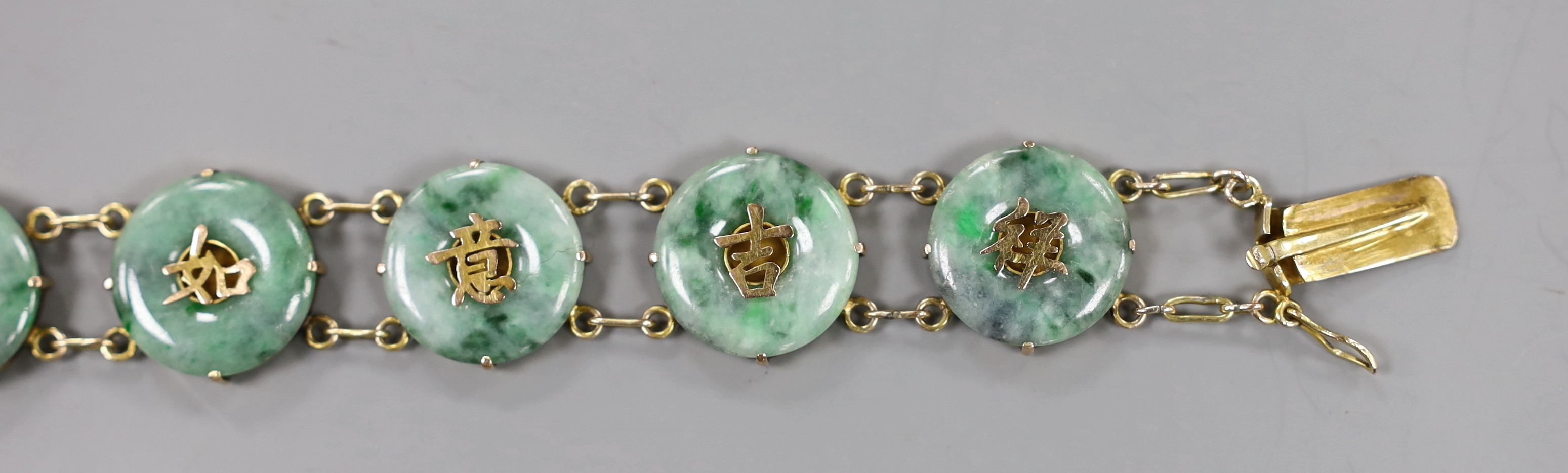 A Chinese 18k yellow metal and jadeite disc link set bracelet, 17.5cm, gross weight 20.6 grams.